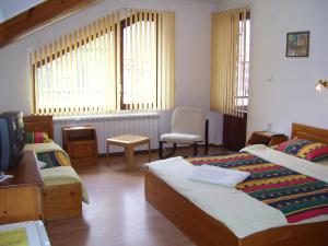 a hotel room with two beds and a tv at Rahoff hotel in Bansko