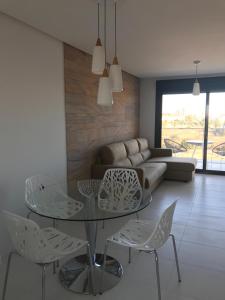 ein Wohnzimmer mit einem Glastisch und Stühlen in der Unterkunft Bioko II Mil Palmeras in Pilar de la Horadada