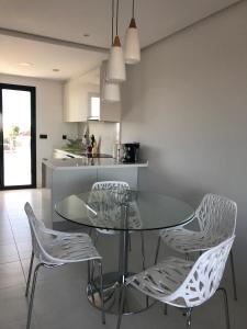 eine Küche mit einem Glastisch und 2 Stühlen in der Unterkunft Bioko II Mil Palmeras in Pilar de la Horadada