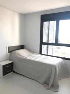 ein weißes Schlafzimmer mit einem Bett und einem Fenster in der Unterkunft Bioko II Mil Palmeras in Pilar de la Horadada