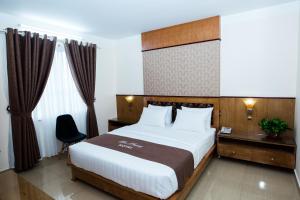 a hotel room with a bed and a chair at Hoa Phuong Hotel in Hai Phong