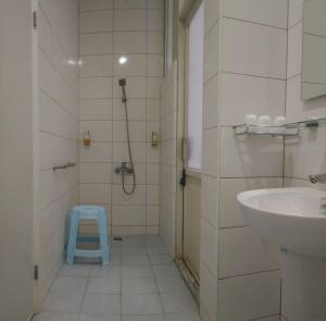 a bathroom with a sink and a shower with a blue stool at Wooden Man Homestay in Taitung City