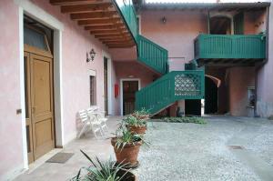 un edificio con scale verdi e piante in vaso in un cortile di Hotel Sogno a Rezzato