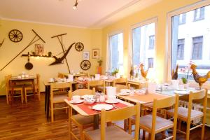 a dining room with tables and chairs and clocks on the wall at Barcelona Bed & Breakfast in Düsseldorf