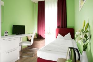 1 dormitorio con 1 cama y escritorio con ordenador en Barcelona Bed & Breakfast en Düsseldorf