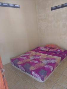 a small bed in a corner of a room at Kona backpaker syariah in Yogyakarta