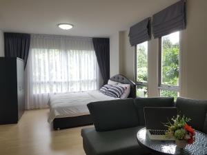 a bedroom with a couch and a bed with a laptop at Dcondo Kathu Patong Phuket by Jack in Kathu