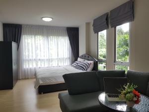 a bedroom with a couch and a bed with a laptop at D Condo Kathu-Patong Phuket by Jacky in Kathu