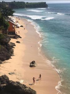 a group of people walking on a beach at Tanjung Sari Inn in Nusa Dua