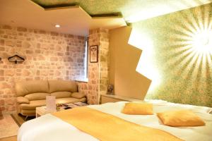 una camera d'albergo con letto e divano di Hotel Coco de Sole & Coco de Mono(Love Hotel) a Oita