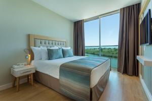 A bed or beds in a room at Aska Lara Resort & Spa Hotel