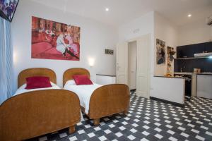 カリアリにあるSuite d'artのベッド2台とキッチンが備わるホテルルームです。