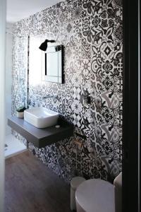 a bathroom with a black and white patterned wall at Alicante loft in Alicante