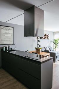a kitchen with a black island in a living room at Alicante loft in Alicante