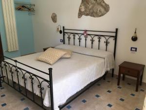 a bedroom with a bed with white sheets and a table at Luna D'Agerola in Agerola