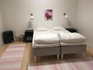 1 dormitorio con 1 cama con sábanas blancas y 2 lámparas en Lilla Vrån, en Lerbäcken