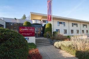 een gebouw met een bord ervoor bij Bastion Hotel Bussum Hilversum in Bussum