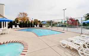 een zwembad met ligstoelen en een volleybalveld bij Hawthorn Suites By Wyndham Columbus North in Columbus