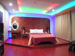 una camera con letto e soffitto arcobaleno di New Bale Motel a Bali