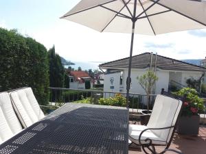 - une table et des chaises avec un parasol sur la terrasse dans l'établissement Oberhof, à Bodman-Ludwigshafen