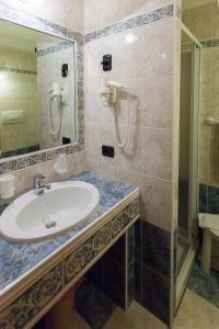 uma casa de banho com um lavatório e um chuveiro em Garden Hotel Bellariva em Molveno