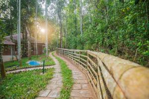 un pont au milieu d'une forêt dans l'établissement Raindrops Resorts, à Sultan Bathery
