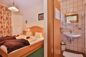 una camera da letto con un letto e un lavandino di Hotel Beim Winkler a Tröpolach