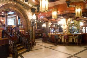 eine Bar in einem Pub mit einer Steinmauer in der Unterkunft Benedicts Hotel in Belfast