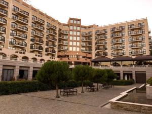 a large building with tables and benches in front of it at Studio Elegance in Golden Sands