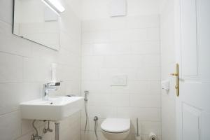 a white bathroom with a sink and a toilet at Lake view suites Villa Julia by we rent in Zell am See +28 photos