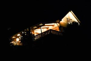 een 's nachts verlicht huis met een balkon bij Romantikhütte Rothaarsteig in Schmallenberg