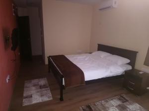 una camera da letto con letto, lenzuola e cuscini bianchi di Prenoćište HRAST a Paraćin