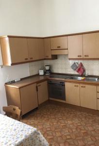 a small kitchen with wooden cabinets and a table at Appartamento Nadia in Merano