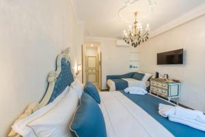 a bedroom with two beds and a chandelier at B&B Palazzo Montesanto in Maiori