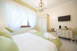a bedroom with a large white bed with a chandelier at B&B Palazzo Montesanto in Maiori