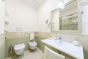 a bathroom with a toilet and a sink and a mirror at B&B Palazzo Montesanto in Maiori