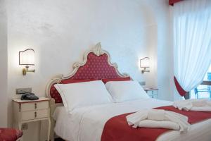a bedroom with a red and white bed with towels on it at B&B Palazzo Montesanto in Maiori