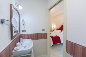 a bathroom with a sink and a mirror and a bed at B&B Palazzo Montesanto in Maiori