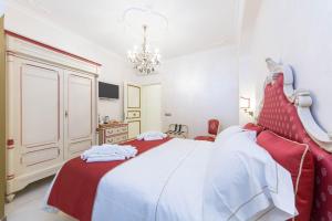 a bedroom with a red and white bed and a chandelier at B&B Palazzo Montesanto in Maiori
