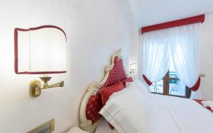 a bedroom with a bed with a mirror and a window at B&B Palazzo Montesanto in Maiori