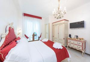 a bedroom with a red and white bed and a chandelier at B&B Palazzo Montesanto in Maiori