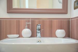 a bathroom sink with two vases on top of it at B&B Palazzo Montesanto in Maiori