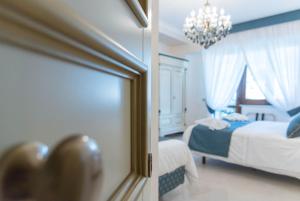 a blue and white bedroom with a bed and a chandelier at B&B Palazzo Montesanto in Maiori