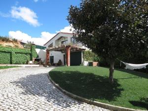 ein Haus mit einem Baum und einer Hängematte im Hof in der Unterkunft Swallow's Countryhouse in Batalha