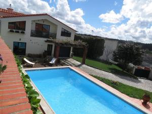 a swimming pool in front of a house at Swallow's Countryhouse in Batalha