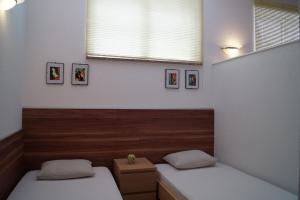 a bedroom with two beds and a window with pictures at Apartments Ginkgo in Banjole
