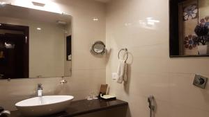 un bagno con lavandino e specchio di The AVR Hotels & Banquets a Patna