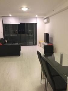 a living room with a couch and a table at Hurstville New apartment with city view in Sydney