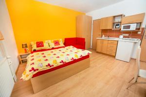 a small bedroom with a bed and a kitchen at Apartmánový dom Adriana in Zuberec