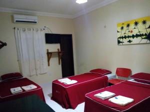 una habitación con mesas y sillas rojas en Pousada Aquino, en Sobral